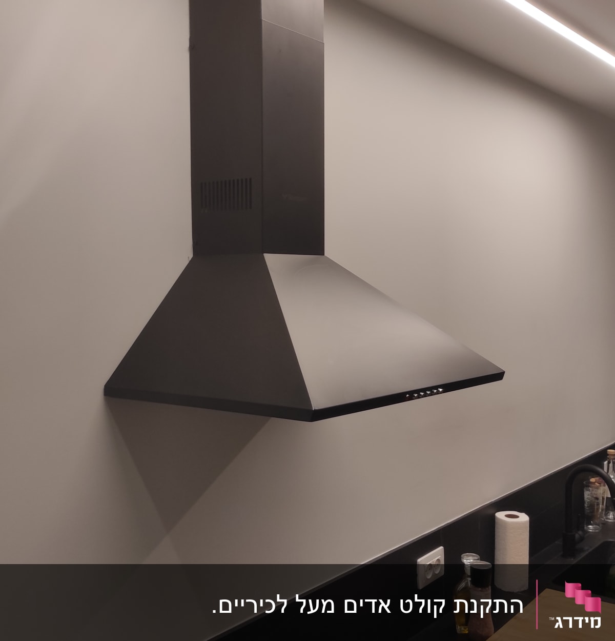 קולט אדים שחור מותקן על קיר במטבח מודרני
